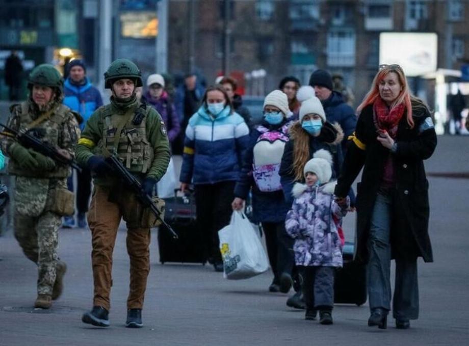 Les forces de sécurité escortant des familles dans un train à évacuer de Kiev (REUTERS/Gleb Garanich)