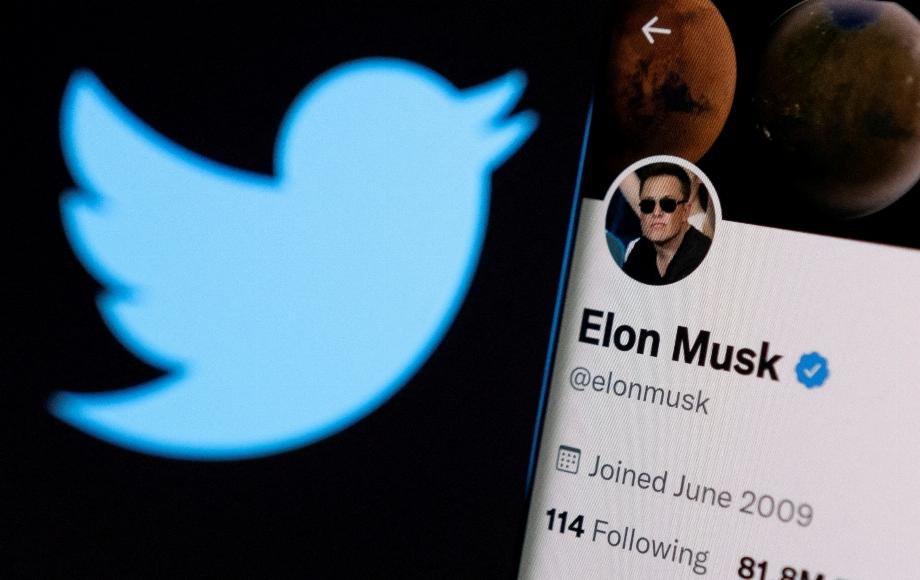 Le compte Twitter d'Elon Musk est affiché sur un smartphone devant le logo Twitter dans cette illustration prise le 15 avril 2022. (REUTERS/Dado Ruvic/File)