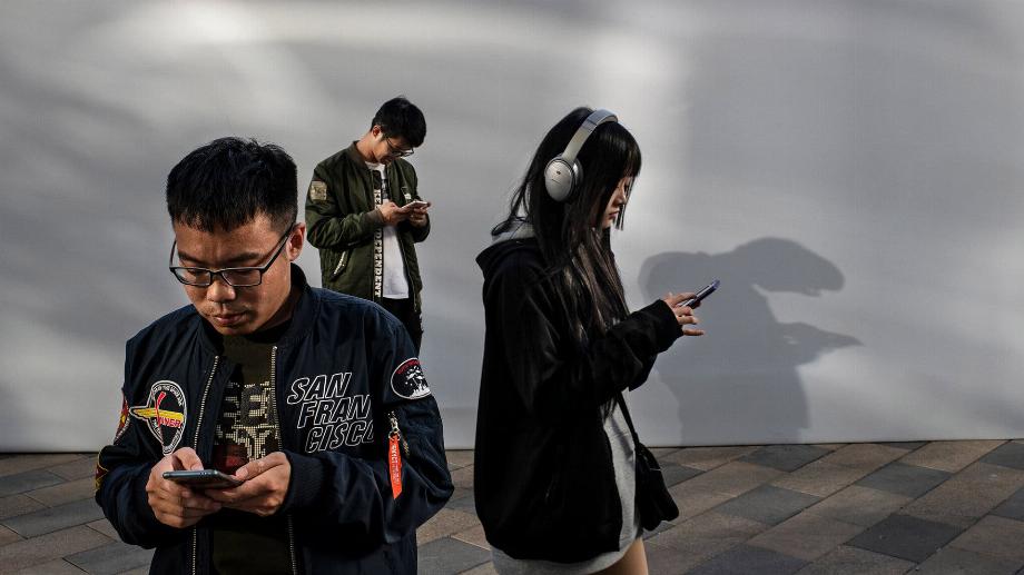 Personnes utilisant leur téléphone portable en Chine (Crédit...Kevin Frayer/Getty Images)