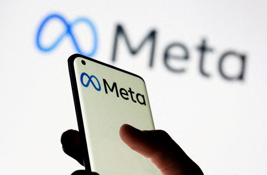 PHOTO DE FICHIER: Une femme tient un smartphone avec le logo Meta devant le nouveau logo Meta de Facebook affiché sur cette photo d'illustration prise le 28 octobre 2021. REUTERS / Dado Ruvic // File Photo
