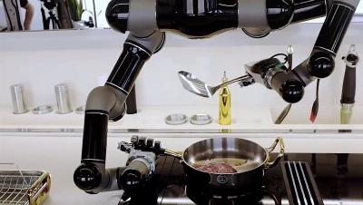 Trois robots de cuisine soutenant le chef avec des bras robotiques