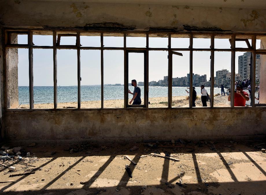 Des gens marchent sur la plage dans l'une des zones clôturées par l'armée turque depuis 1974, dans la zone abandonnée de Varosha, au nord de Chypre. (REUTERS/Harun Ucar/Photo d'archive)