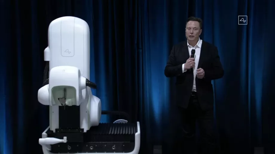 Elon Musk à côté du robot qui serait utilisé en chirurgie pour insérer les puces Neuralink. Forer le crâne pour implanter leurs BCI suscite un débat sur la sécurité et l'éthique de leurs méthodes. (Archive)