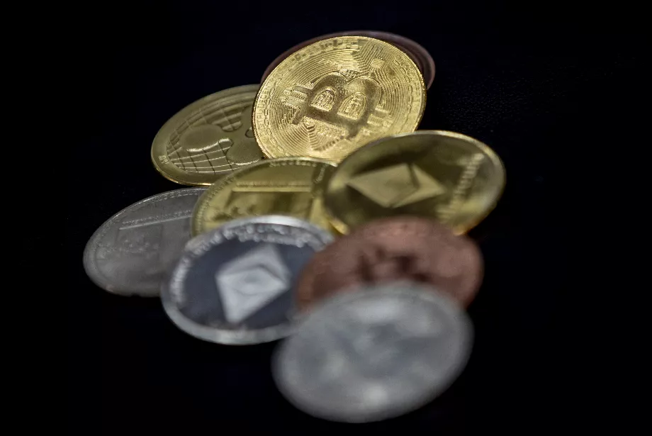 Représentations physiques de diverses crypto-monnaies sur la carte mère d'un ordinateur (EFE/Sedat Suna)