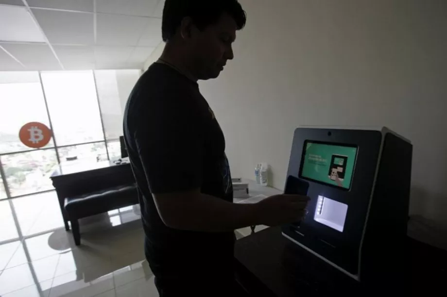 Juan Mayén, PDG de la société hondurienne TGU Consulting Group, montre comment utiliser un guichet automatique de crypto-monnaie à Tegucigalpa, au Honduras. (Reuters/Fredy Rodriguez)