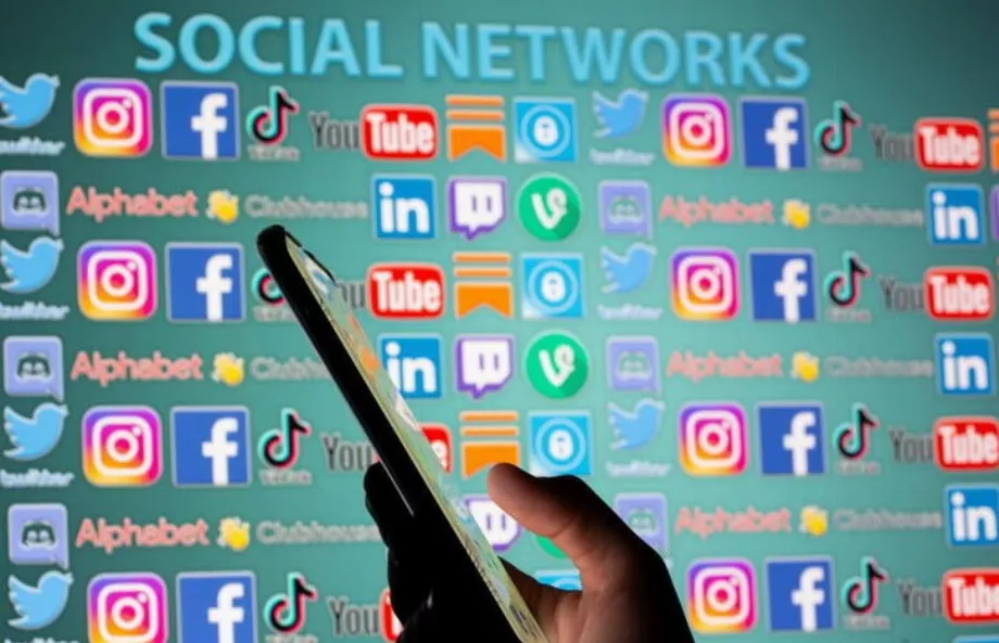 PHOTO DE FICHIER. Image d'illustration d'une femme avec un smartphone devant les logos des médias sociaux. (Reuters/Dado Ruvic)