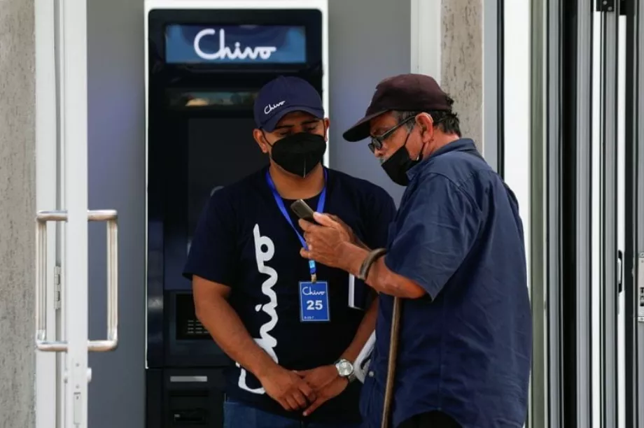 Un travailleur aide un homme à utiliser Bitcoin devant un guichet automatique « Chivo », le portefeuille numérique soutenu par le gouvernement salvadorien, à San Salvador, au Salvador. 8 septembre 2021. (REUTERS/Jose Cabezas)