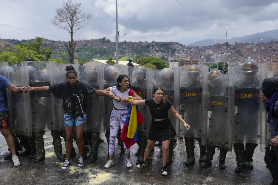Plusieurs citoyens tentent de bloquer une rue en protestation contre les résultats officiels le jour après les élections présidentielles (AP Photo/Cristian Hernández)