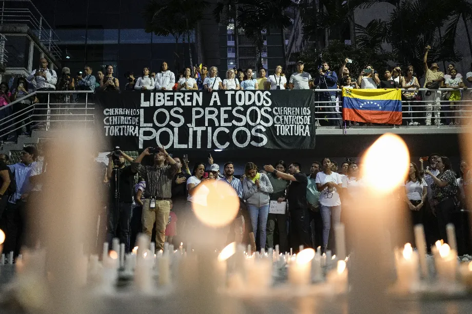 Des proches des détenus pendant la répression gouvernementale des manifestations contre les résultats des élections présidentielles participent à une veillée à Caracas, Venezuela, le 8 août 2024. La pancarte dit "Libérez tous les prisonniers politiques" (AP Photo/Matías Delacroix)