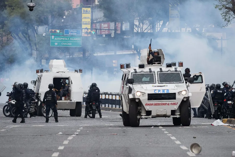 Des effectifs de la Police nationale bolivarienne affrontent des manifestants à Caracas lors d'une protestation contre les résultats des élections (EFE/Ronald Peña R.)