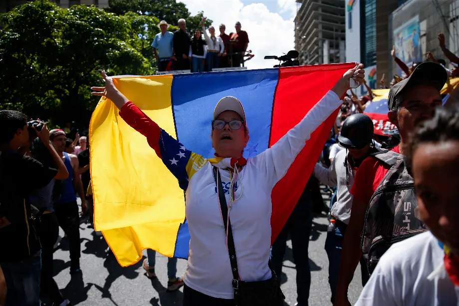 Une femme déploie le drapeau vénézuélien pendant la protestation contre la fraude à Caracas (REUTERS/Leonardo Fernandez Viloria)