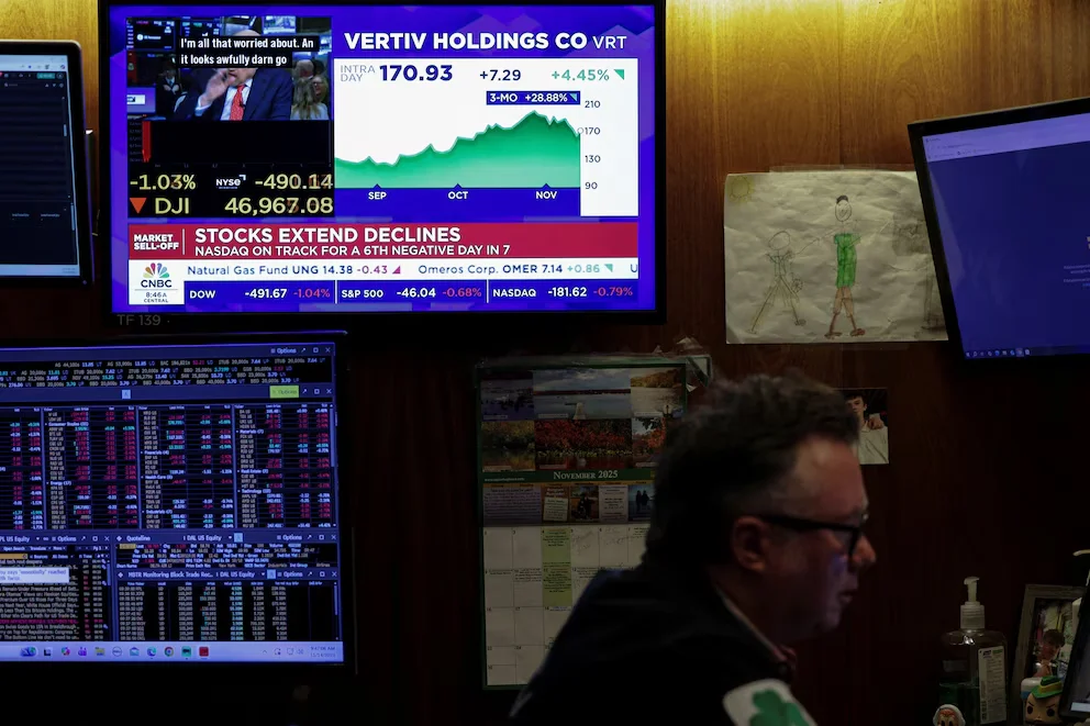 Un écran affiche des données d'indices boursiers pendant que les opérateurs travaillent dans la salle de la Bourse de New York (NYSE) à New York, États-Unis, le 14 novembre 2025. REUTERS/Jeenah Moon